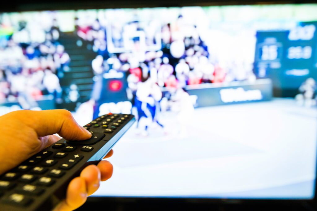 Advertise on TV Human hand holding the remote control